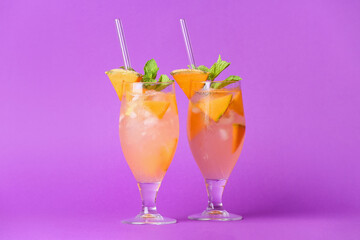 Glasses of cold melon cocktail on lilac background