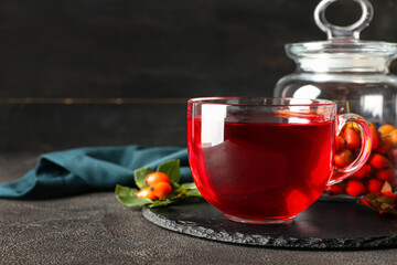 Glass cup of tasty rose hip tea on table