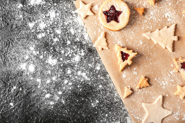 Preparing of tasty Linzer cookies on dark background