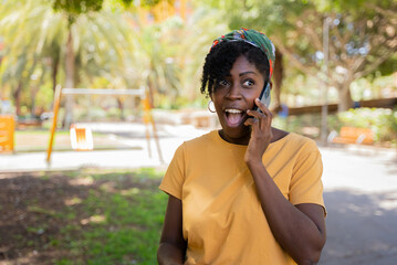 Fototapeta premium shocked afro young woman talking on the mobile phone