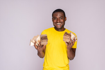 excited and happy young black man holding a lot of money in both hands