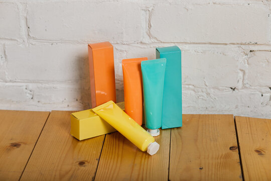 Colorful tubes of bathroom amenity contains of cream, body lotion. Yellow, orange and aquamarine colored tubes