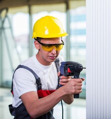 Man drilling the wall with drill perforator