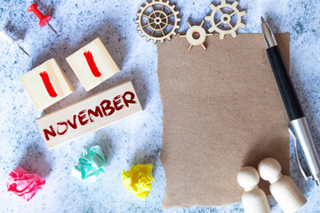 November 11. Day 11 of month, Cube calendar with date, empty frame on light blue background.