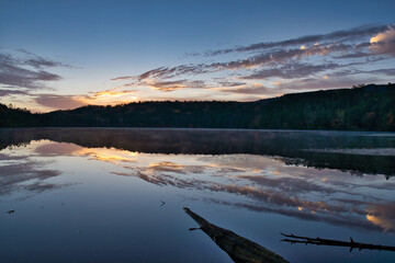 美しい紅葉の白駒池の湖面に反射する日の出