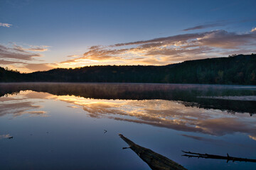 美しい紅葉の白駒池の湖面に反射する日の出