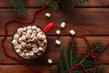 Christmas drinks. Festive background with Christmas tree branches and hot chocolate with marshmallows on wooden table. Top view