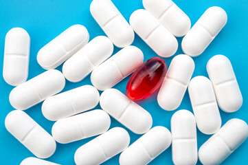Pain therapy, headache medication and pharmaceutical industry concept with one red pill surrounded...