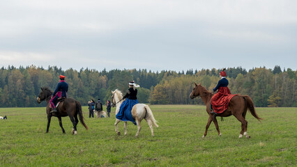 Group of fox hunters on the horses in the autumn field. Reconsruction of traditional horse hunting.