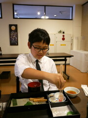 法事で食事する少年