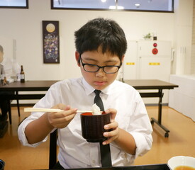 法事で食事する少年