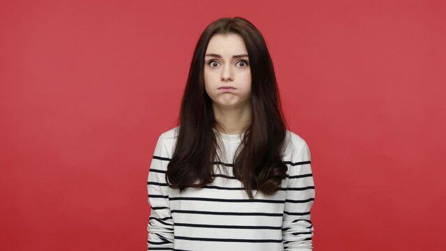 Woman making explosion gesture as her head gonna explode, being angry and nervous, having problems, wearing casual style long sleeve shirt. Indoor studio shot isolated on red background.