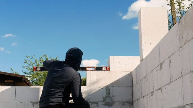 The horizontal gauge is in the hands of the builder at the construction site. The builder measures the angle of inclination