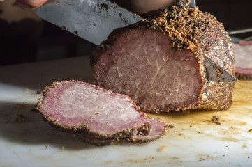 meat with the name of "cupim", hump steak, cut of beef from the upper part of the ox, widely consumed in Brazil, smoked and sliced ​​​​on a white board, copy space and selective focus