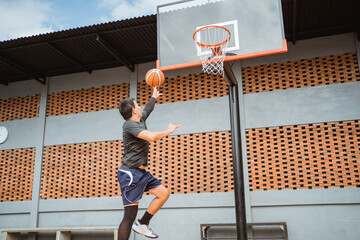 a male basketball player jump shot with the ball