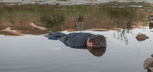 the body of a man who drowned, lying face down in the water lifeless body