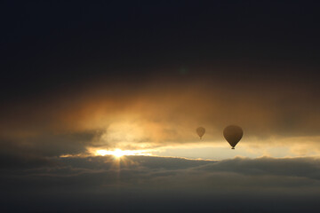two balloons in flight with hot air, against the background of dark clouds