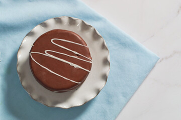 Close up of chocolate alfajor on porcelain plate. Gastronomy of argentina