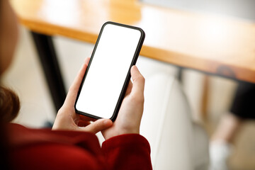 Woman holding and Using smartphone blank screen in the mall. Take your screen to put on advertising.