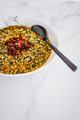vegan buckwheat with spicy broth and spinach topped with sundried tomatoes, healthy plant-based food