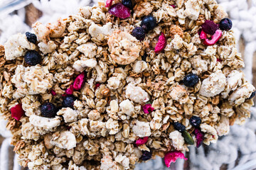 vegan homemade granola with oats grains and dried fruits in glass lunch box, healthy plant-based food