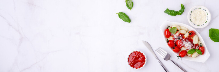 Gnocchi with tomatoes, red sauce, cheese and basil leaves