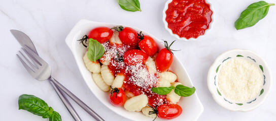 Gnocchi with tomatoes, red sauce, cheese and basil leaves