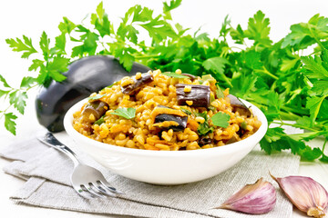Bulgur with eggplant in bowl on wooden board