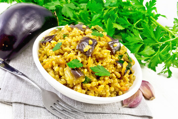 Bulgur with eggplant in bowl on light board