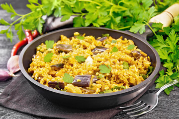Bulgur with eggplant in pan on board