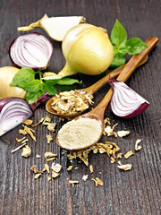 Onion powder and flakes in spoons on wooden board