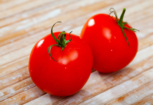Image of red tomatoes on wooden table in home kitchen