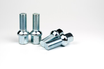 shiny metal bolts fastening a car wheel close-up on a white background. car spare part