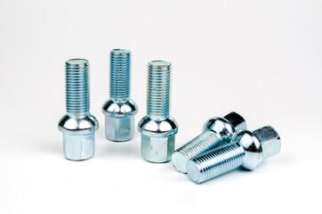 shiny metal bolts fastening a car wheel close-up on a white background. car spare part