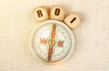 On the table is a compass and cubes with the inscription - ROI