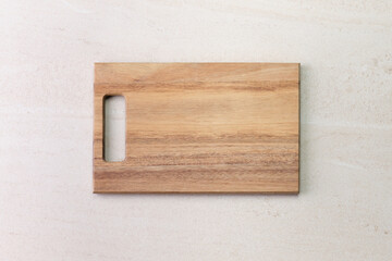 Wooden cutting board on old beige marble surface. Top view with copy space for product or text.