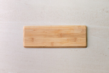 Wooden board on old beige marble surface. Top view with copy space for product or text.