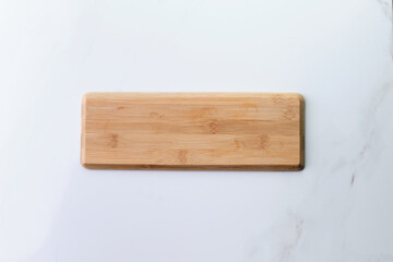Wooden board on old white marble surface. Top view with copy space for product or text.