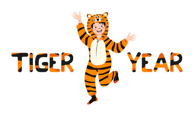 Fototapeta na wymiar Boy in tiger carnival costume and inscription New Year from striped orange with black letters. Children pajama party or holiday. Kid in jumpsuits or kigurumi, festive clothing for Christmas