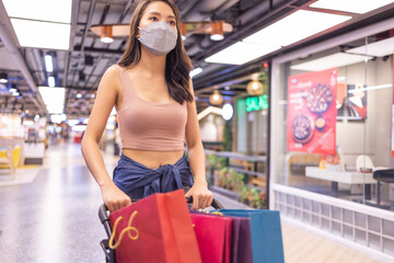 Happy woman with shopping bags enjoying in shopping. Girl holding colour paper bag.Friends walking in shopping mall.time shopping coronavirus crisis or covid19 outbreak.