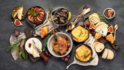 French food assortment on dark background.