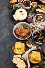 French food assortment on dark background.