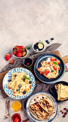 Sweet crepes assortment with berries chocolate on gray background.