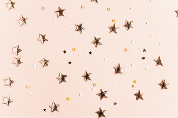 Festive background with gold stars and glitter on a solid beige background. Bright postcard for...
