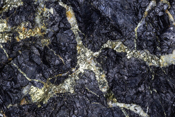 Golden Iron Pyrite (Fool's Gold), creating a veined pattern in a sample of black galena (lead ore.)...