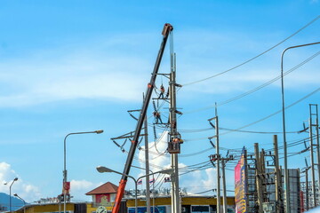 Naklejka premium Repairing high voltage poles on the crane work at height risk