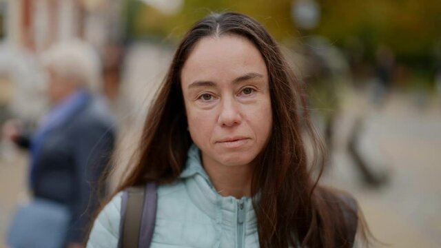 Close-up portrait of a feminist woman looking into a camera on city street. People of feminism are confronted with a close-up portrait