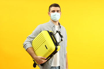 Traveling concept during coronavirus with young man on yellow background
