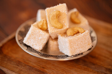 Turkish sweets on small plate on brown wooden background