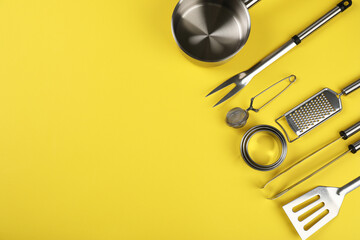 Kitchen utensil on yellow background, space for text